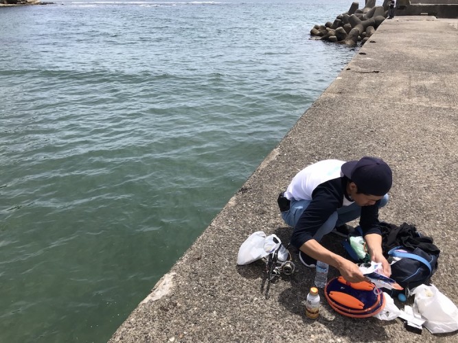 千葉の堤防で釣りの準備をしている様子。雨上がりの後のため、海が少し濁っている。